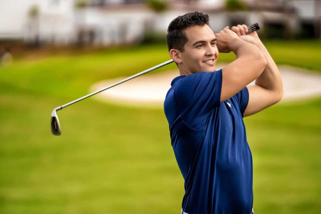 Man swinging a golf club on the course at Reunion Resort.