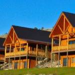Row of member cabins overlooking a vast equestrian pasture at The Ranches at Belt Creek.