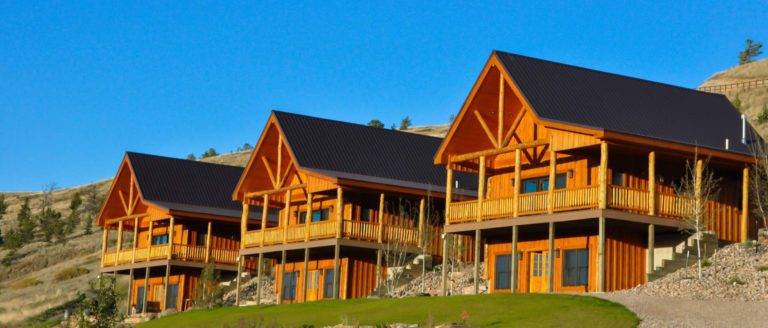 Row of member cabins overlooking a vast equestrian pasture at The Ranches at Belt Creek.