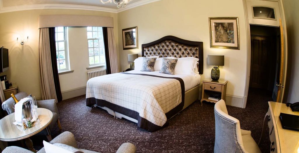 Deluxe room king bed, sitting area, and workstation at Brockencote Hall