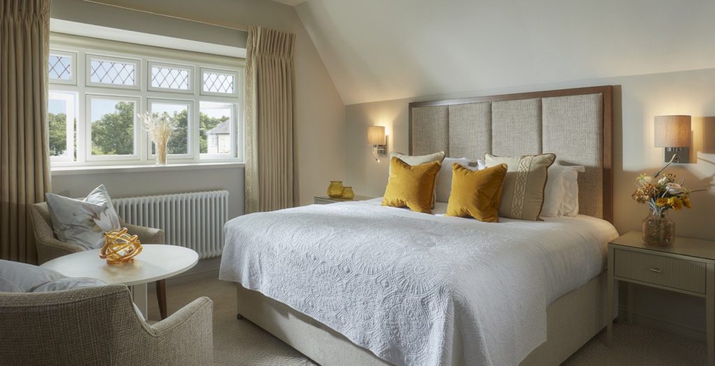 Lodge king bedroom with sitting area at Brockencote Hall