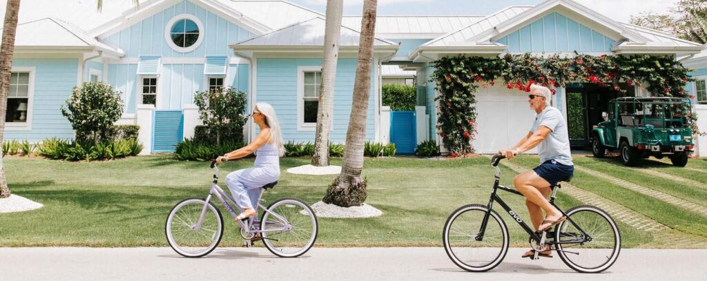 Older couple bike riding on a street in Naples, Florida