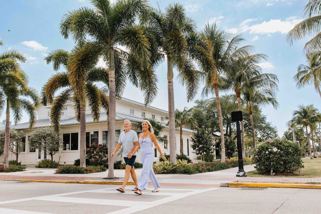 Older couple walking on a crosswalk in downtown Naples, Florida