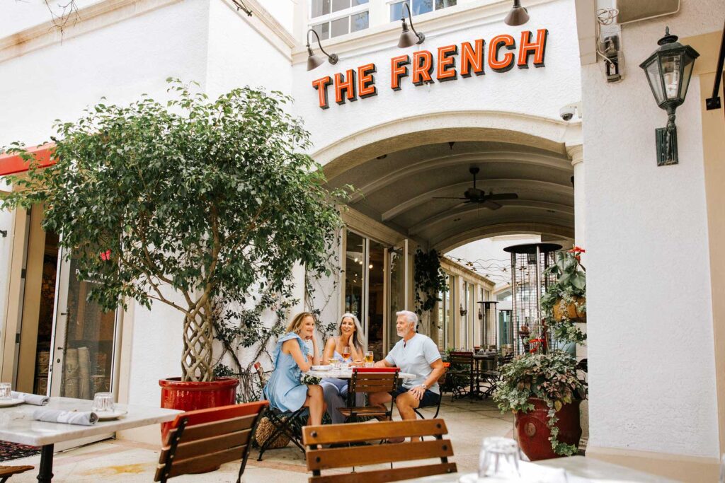 Family enjoying a sit-down meal outside of the French restaurant in Naples, Florida