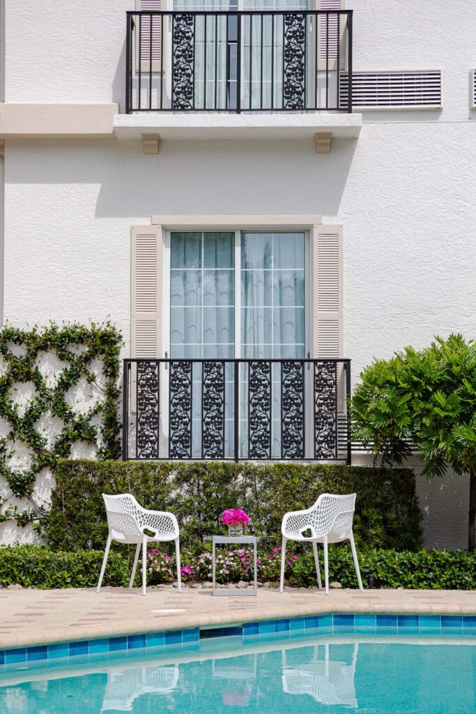Small table and chairs set up on the side of the pool at the Capri Inn