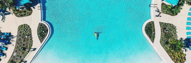 Aerial view of a woman floating by herself in the Fins Up pool at Margaritaville Resort Orlando.