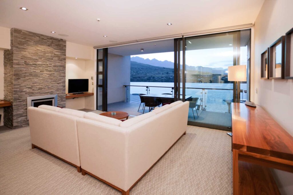 Executive Lake View 2 Bedroom Apartment living room with sectional sofa and balcony access