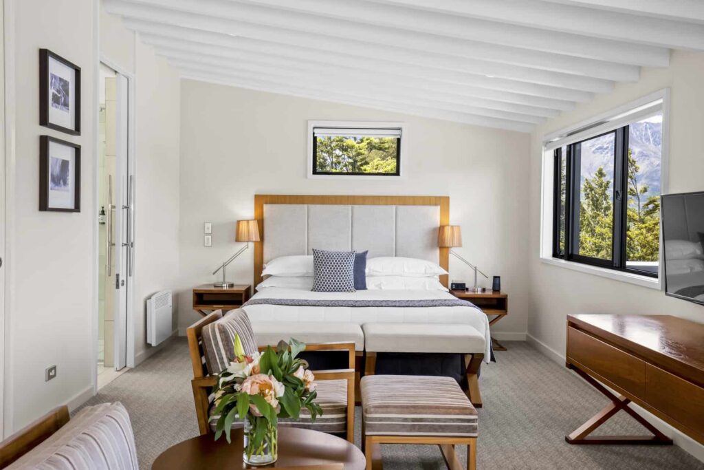 Bedroom suite with cushioned armchairs and large desk: Executive Lake View Hotel Room