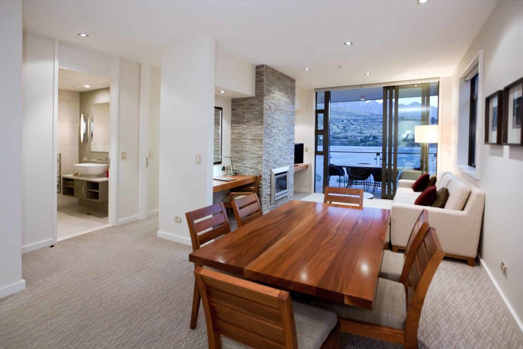 Dining and living room with balcony access and fireplace: Lake View 2 Bedroom Apartment