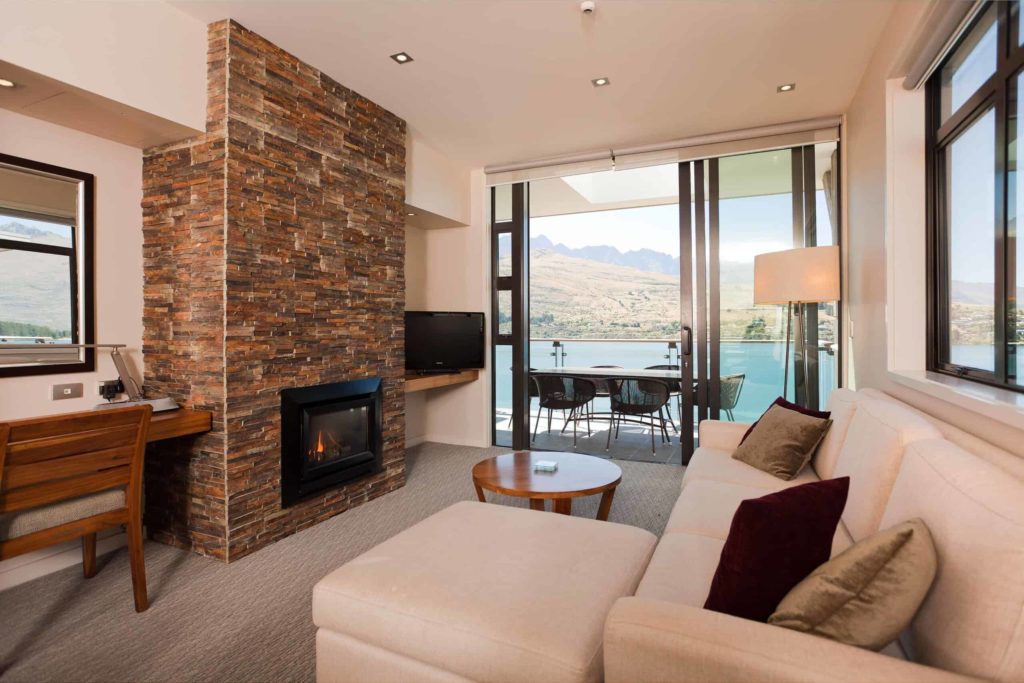 Living room with fireplace and balcony access: Lake View 2 Bedroom Apartment