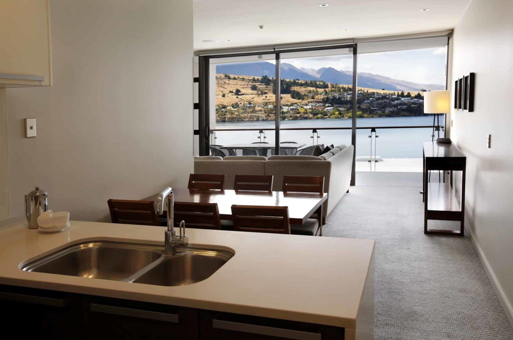Kitchen, dining, and living room with balcony access: Lake View 3 Bedroom Apartment
