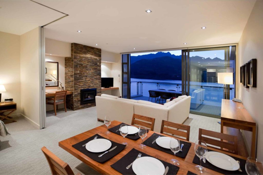 Dining and living room with balcony and fireplace: Lake View 3 Bedroom Apartment