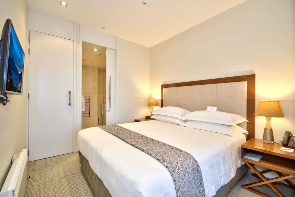 Superior Apartment bedroom suite with king bed and wall mounted TV
