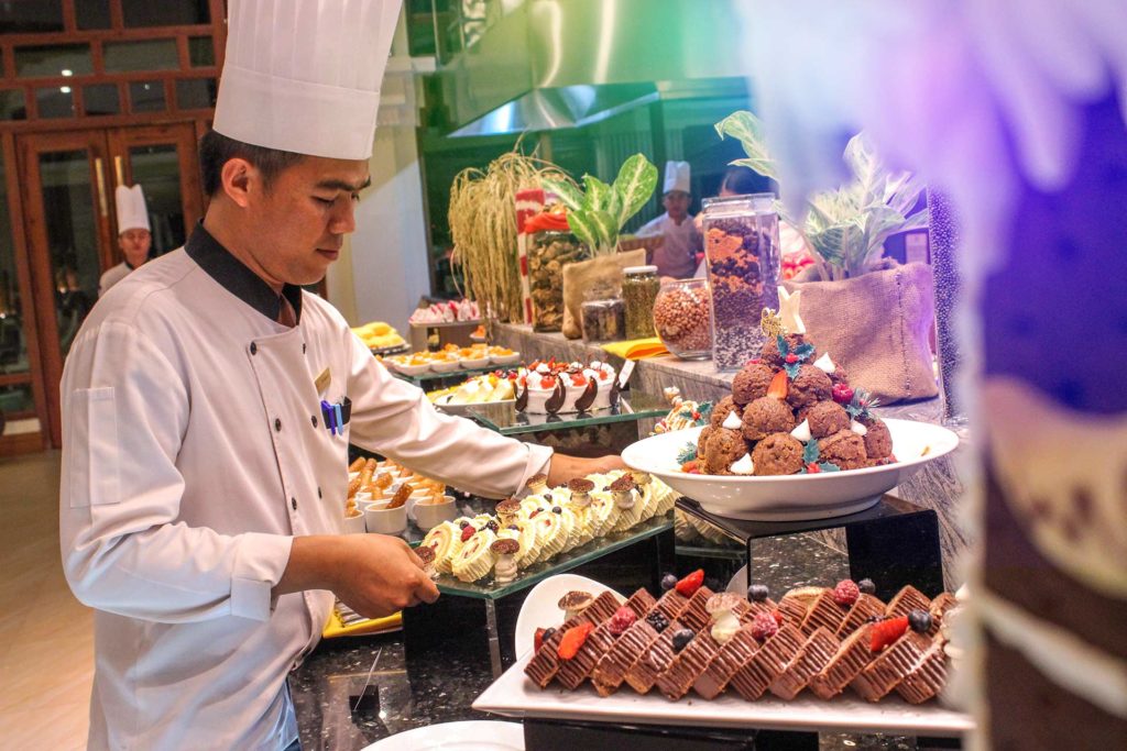 Chef laying out trays at buffet of Tumeric Restaurant of the Sokha Siem Reap Resort