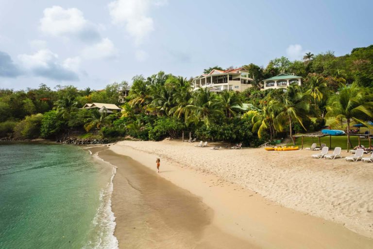 Woman walking along the beach at Calabash Cove