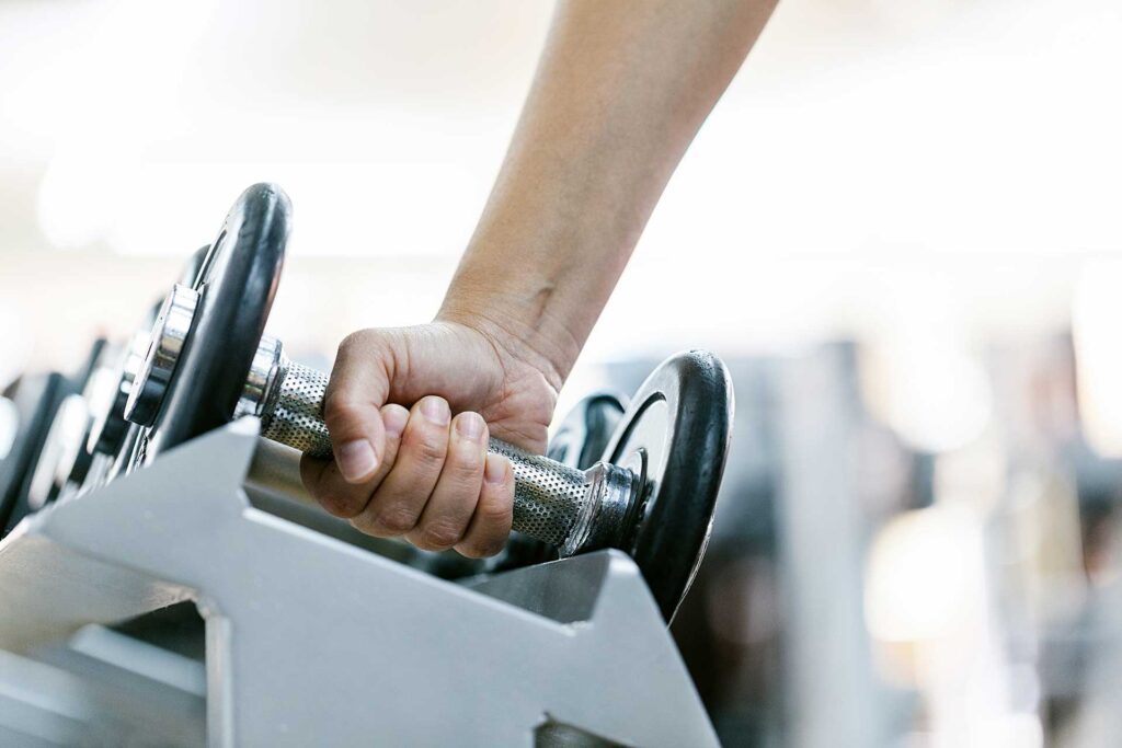 Woman taking weights off a shelf in a fitness center